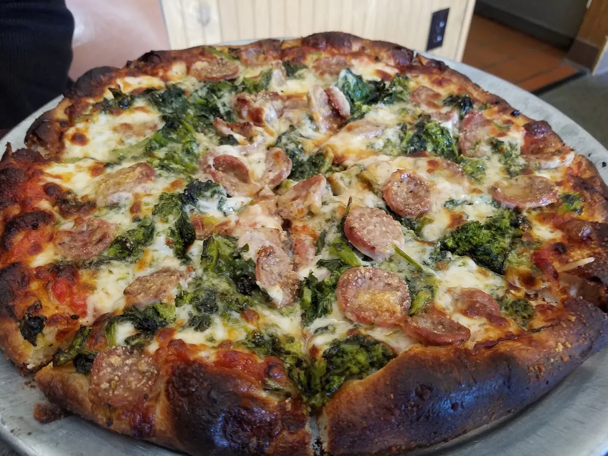 Pizza topped with broccoli, sliced sausage and cheese at Ernie's